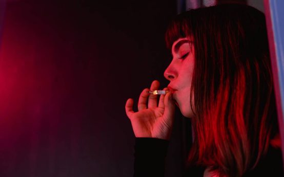 Imagen de una chica joven dependiente de fumar drogas