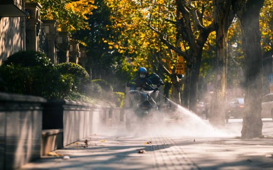 Imagen de un trabajador de una empresa de fumigaciones en Madrid realizando su trabajo en motocicleta en un dia de otoño en la capital de España