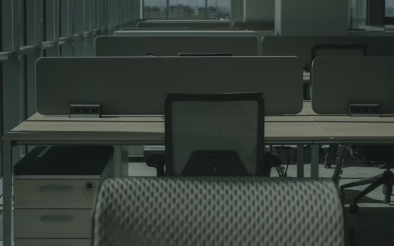 Imagen de mobiliario de oficina moderno y funcional tras una jornada de trabajo en la que los empleados ya se han retirado de sus puestos de trabajo