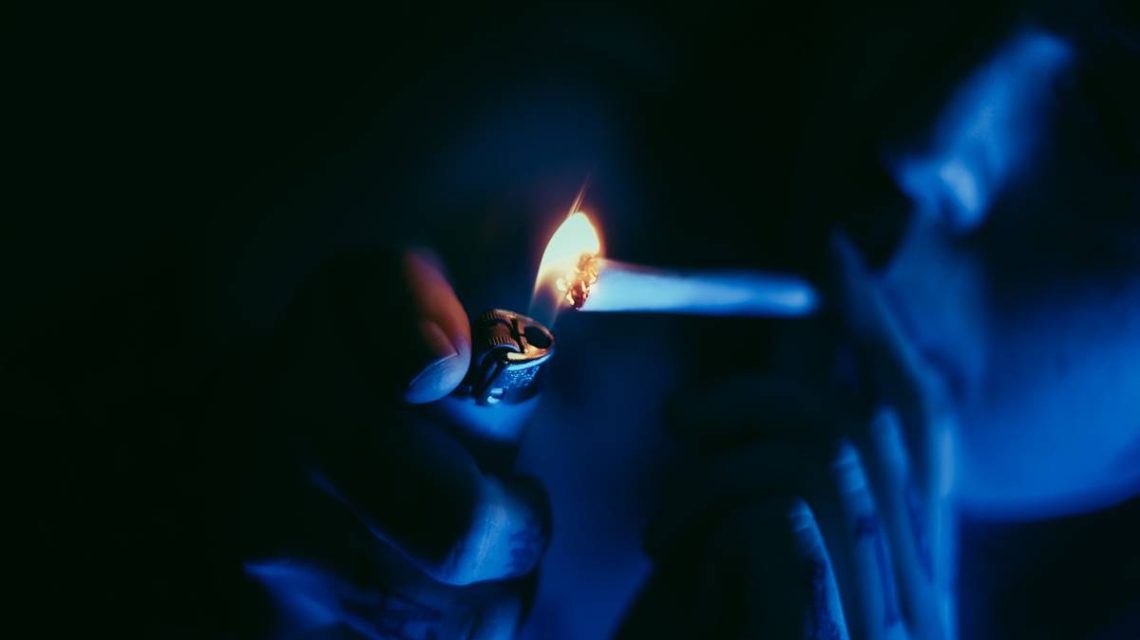 joven pendiente de superar una adiccion encendiendo un cigarrillo