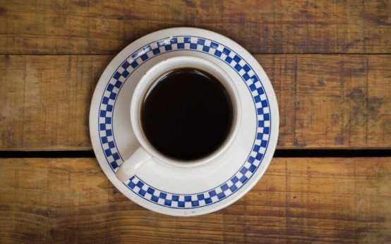 Imagen de una taza de cafe solo tomada desde una perspectiva en la que se ve todo el conido y su color negro molido